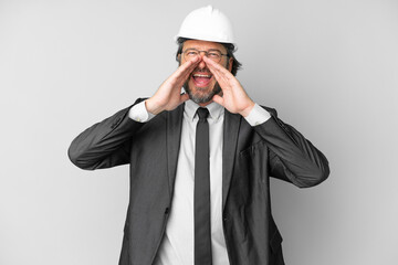 Young architect man with helmet over isolated background shouting and announcing something