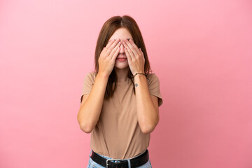 Young English woman isolated on pink background covering eyes by hands