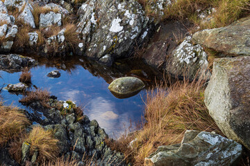 A close view of stone on the beach in the Norway at the cliff in calm water.Autumn. Travel. Skudeneshavn.