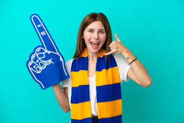 Young sports fan woman isolated on blue background making phone gesture. Call me back sign