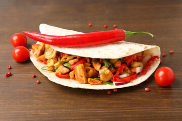 Concept of tasty food with taco on wooden background