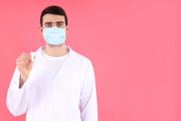 Doctor intern holds tampon on pink background