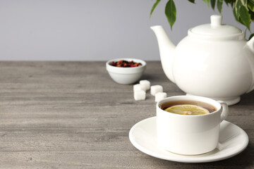 Concept of hot drink with tea on gray wooden table