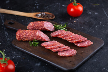 Fresh sausages and ham slices on wooden cutting board, delicious snack, spicy and high quality meat products made of pork and veal, beef.
