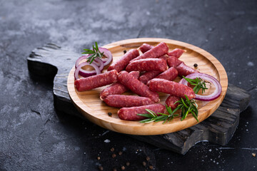 Fresh sausages and ham slices on wooden cutting board, delicious snack, spicy and high quality meat products made of pork and veal, beef.