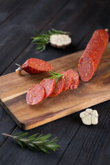 Fresh sausages and ham slices on wooden cutting board, delicious snack, spicy and high quality meat products made of pork and veal, beef.