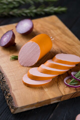Fresh sausages and ham slices on wooden cutting board, delicious snack, spicy and high quality meat products made of pork and veal, beef.