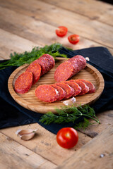 Fresh sausages and ham slices on wooden cutting board, delicious snack, spicy and high quality meat...