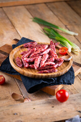 Fresh sausages and ham slices on wooden cutting board, delicious snack, spicy and high quality meat...