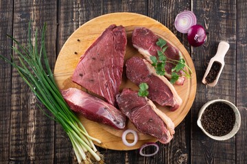 Fresh beef pieces on cutting board, delicious looking ready for steak, with pepper and salt, quality veal meat