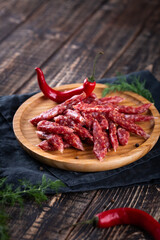 Fresh sausages and ham slices on wooden cutting board, delicious snack, spicy and high quality meat products made of pork and veal, beef.