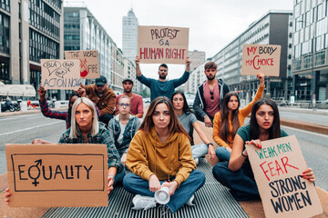 group of young people holding protest banners in a march for the woman rights and gender equality - obrazy, fototapety, plakaty