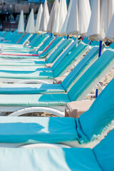Empty blue sunbeds on a modern beach