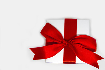 A silver gift box with red bow on white background, christmas holiday concept