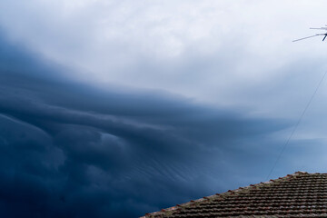 The storm is coming. Storm clouds above the roof. Heavy torrential rain. Rainfall flash flooding ....