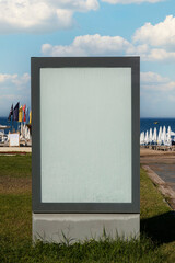 Blank billboard by the sea, on the grass and under cloudy sky. Ideal photo for holiday brochure....