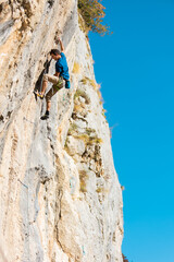A strong man climbs a rock
