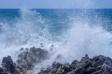 USA, Hawaii, Big Island of Hawaii. Keauhou Bay, Eroded volcanic, shoreline rock (aa) and crashing waves.