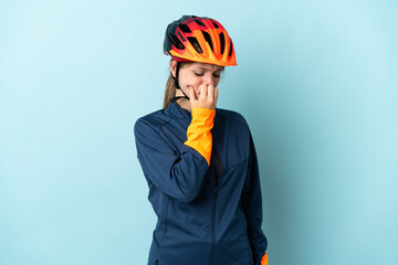 Young cyclist woman isolated on blue background having doubts - obrazy, fototapety, plakaty