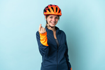 Young cyclist woman isolated on blue background making money gesture