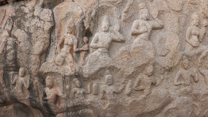 Arjuna's penance - ancient. Statues carved into the wall of the Mahabalipuram rock. The rock wall is located in the background.