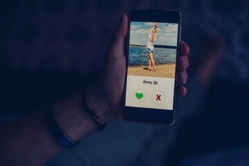 Man using dating app and swiping user photos. Mobile app. - obrazy, fototapety, plakaty
