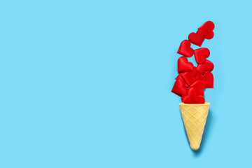 Ice cream cone with red hearts on blue background. Valentines day concept