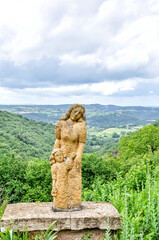 Fototapeta premium Statue of The Douleurs at the beginning of the village of Peyrusse-le-Roc, France