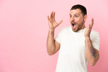 Young Brazilian man isolated on pink background with surprise facial expression