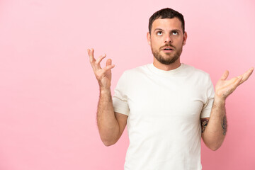 Young Brazilian man isolated on pink background stressed overwhelmed