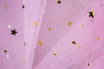 Light pink Crumpled festive tulle fabric (pink, purple, delicate) with sequins in the form of stars...