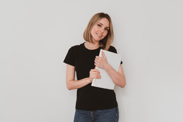 charming European woman in casual clothes holding laptop in her hands Isolated on white background