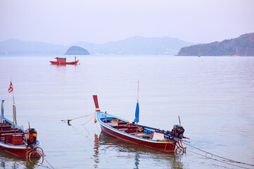 Naklejka na ściany i meble Travel by Thailand. Landscape with traditional longtail fishing boat on the sea beach.