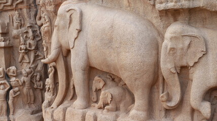Ancient elephant-shaped sculpture carved in rock. And many more sculptures. The rock is located in the background