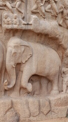 Ancient elephant-shaped sculpture carved in rock. And many more sculptures. The rock is located in the background