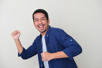 Adult Asian man doing running pose with happy face expression
