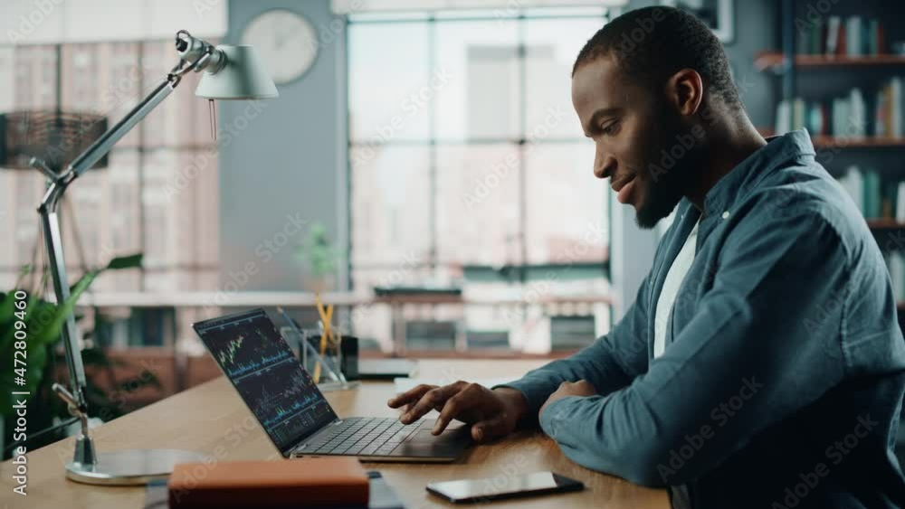 Poster Home Office Day: Black Businessman Using Computer for Analysing Data, Screen Showing Real-Time Stocks, Exchange Market Charts. Remote Working Trader Doing e-Commerce Investment. Side View