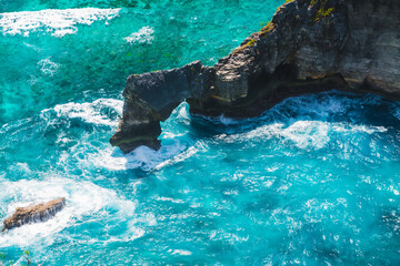 Stones and ocean at Nusa Penida, Indonesia. Blue water with waves with rocks.