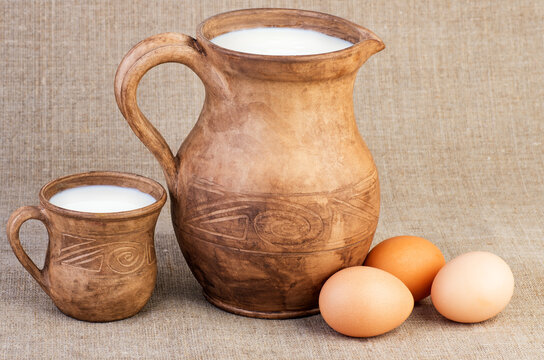 Clay jug and cup of milk, eggs rough fabric