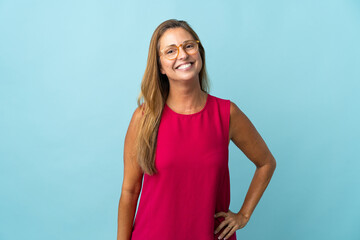 Middle age brazilian woman isolated on blue background with glasses and happy
