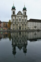 Jesuit Church, the first large Baroque church built in Switzerland north of the Alps, reflected in the River Reuss during winter (Lucerne, Switzerland)
