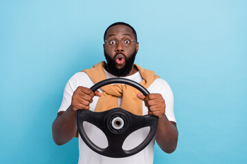 Photo of young amazed shocked guy riding fast speed practicing car driving isolated on blue color background