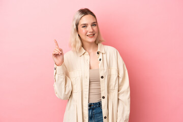 Young caucasian woman isolated on pink background showing and lifting a finger in sign of the best
