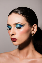 Fototapeta premium Brunette girl, photo portrait, with bright beautiful makeup, with blue eyelids
