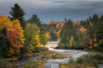 Fototapeta premium Stormy clouds and Lower Tahquamenon Falls, Tahquamenon River in autumn, Tahquamenon Falls State Park, Michigan