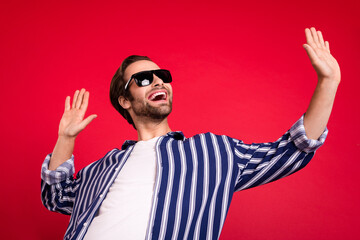 Naklejka premium Photo of young cheerful man have fun eyewear dance chill vacation isolated over red color background