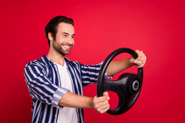 Fototapeta na wymiar Profile side photo of guy riding fast speed work hold steering wheel isolated over red shine color background