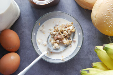  pouring Home Made Musli in a bowl on black,