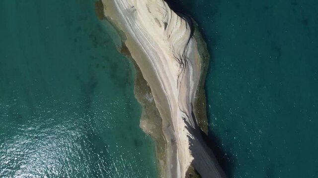A close view of a small island made by clay in the middle of the sea in Greece, Corf&ugrave;. Filmed by drone