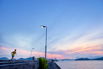 Sports lifestyle. Jogging outdoors. Man running on the sea pier. Motion blur.